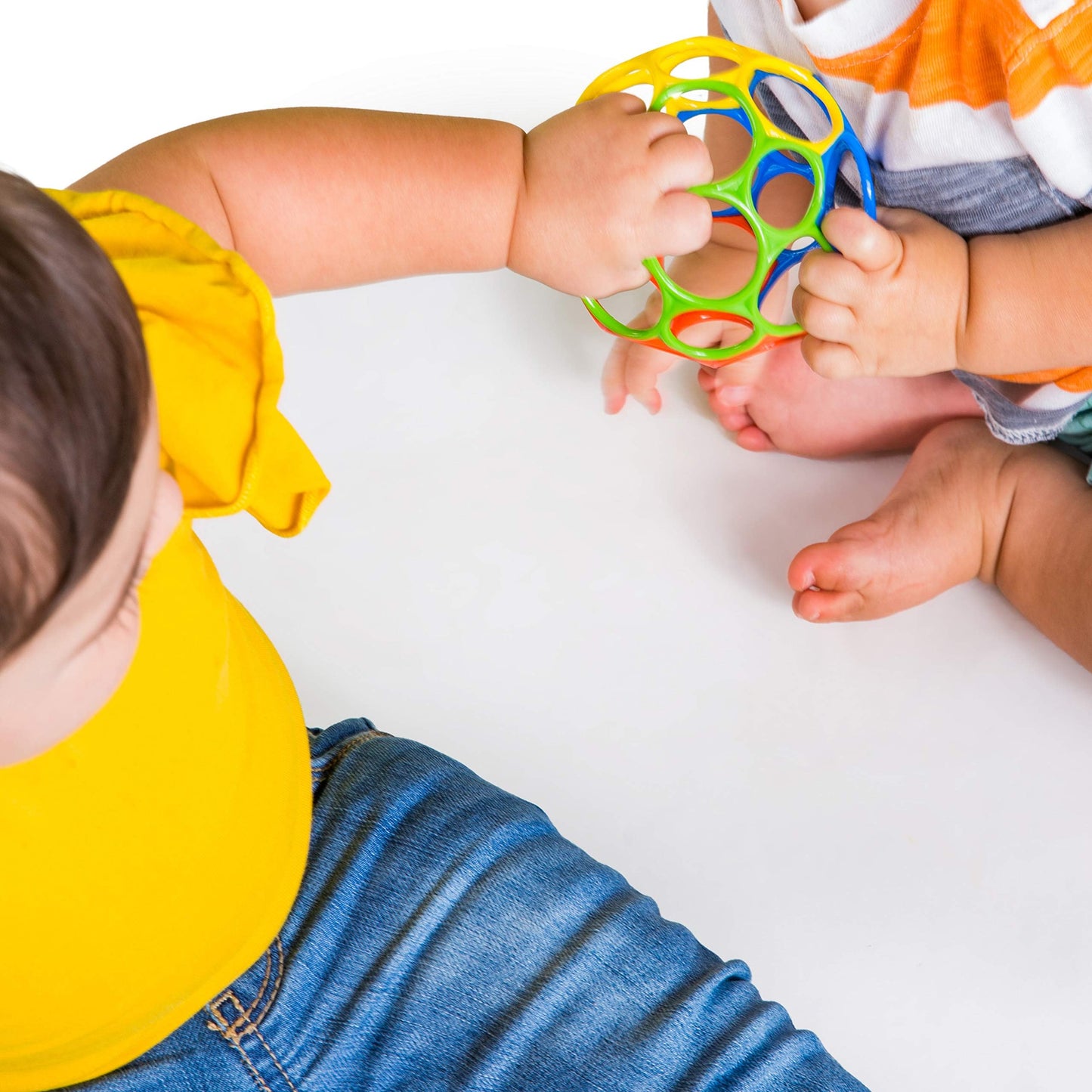 Bright Starts Oball Easy Grasp ball in red, yellow, green, and blue, 4 inches, designed for infants and newborns.