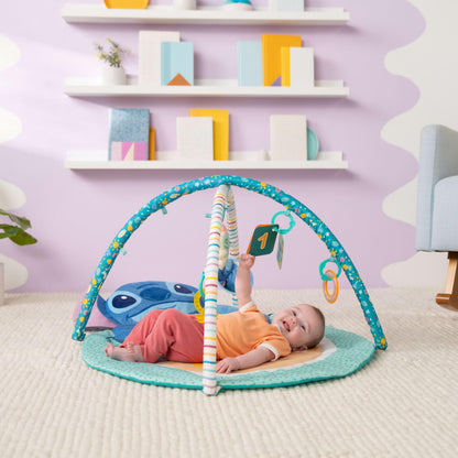 Bright Starts, Disney Baby Stitch Activity Gym, with Tummy Time Pillow, Baby Play Mat with Toy Bar, 5 Take Along Toys, for Newborns and Up