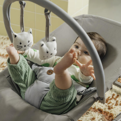 Bebeconfort Aster baby rocker in tinted graphite with adjustable backrest, removable toy arch, 3-point harness, in stationary mode.