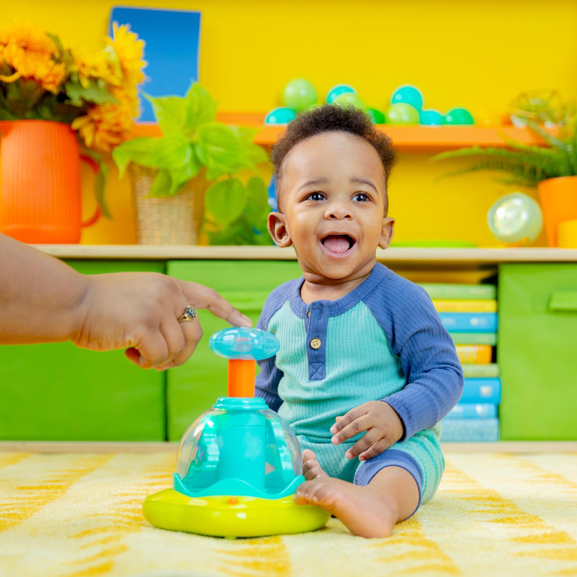 Bright Starts press and glow spinner musical baby toy with multicoloured lights, designed for infants 6 months and older.