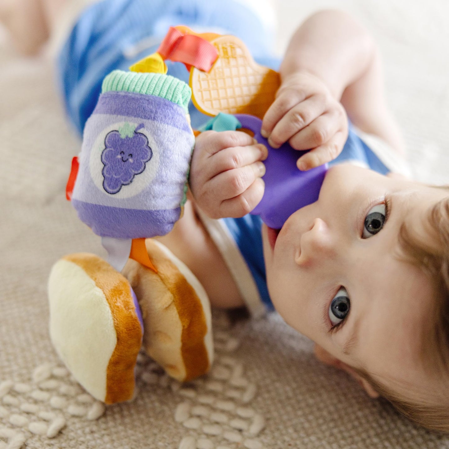Melissa & Doug multi-sensory PB&J take-along clip-on toy for babies and toddlers, featuring colorful sensory elements.