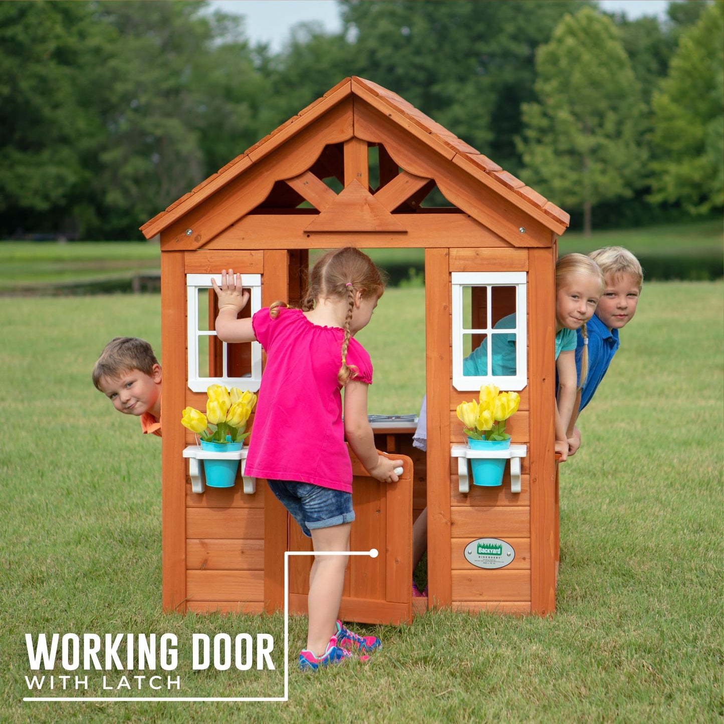 Backyard Discovery Timberlake cedar wood playhouse with toy kitchen, phone, flowerpot holders, for kids aged 2-7, brown outdoor garden structure.