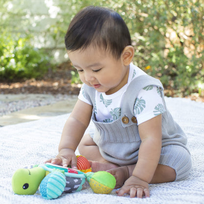Infantino Go Gaga Turtle activity mirror clipped to a stroller for tummy time, sensory play, and peek-a-boo fun for newborns.