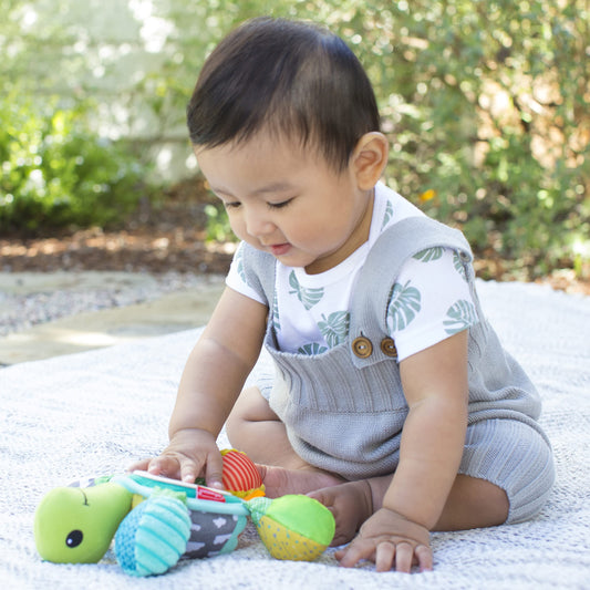 Infantino Go Gaga Turtle activity mirror clipped to a stroller for tummy time, sensory play, and peek-a-boo fun for newborns.