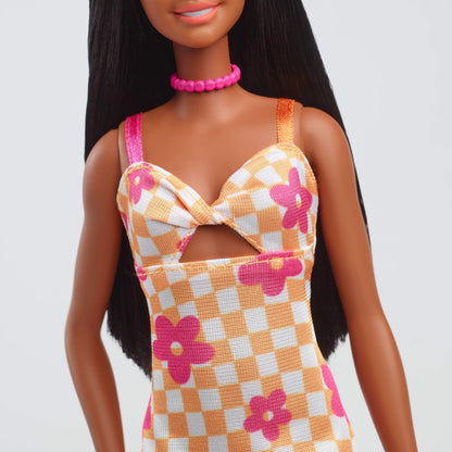 Barbie Fashionistas Doll #233 with black hair in a checkered orange and pink floral midi dress, necklace, and sandals.