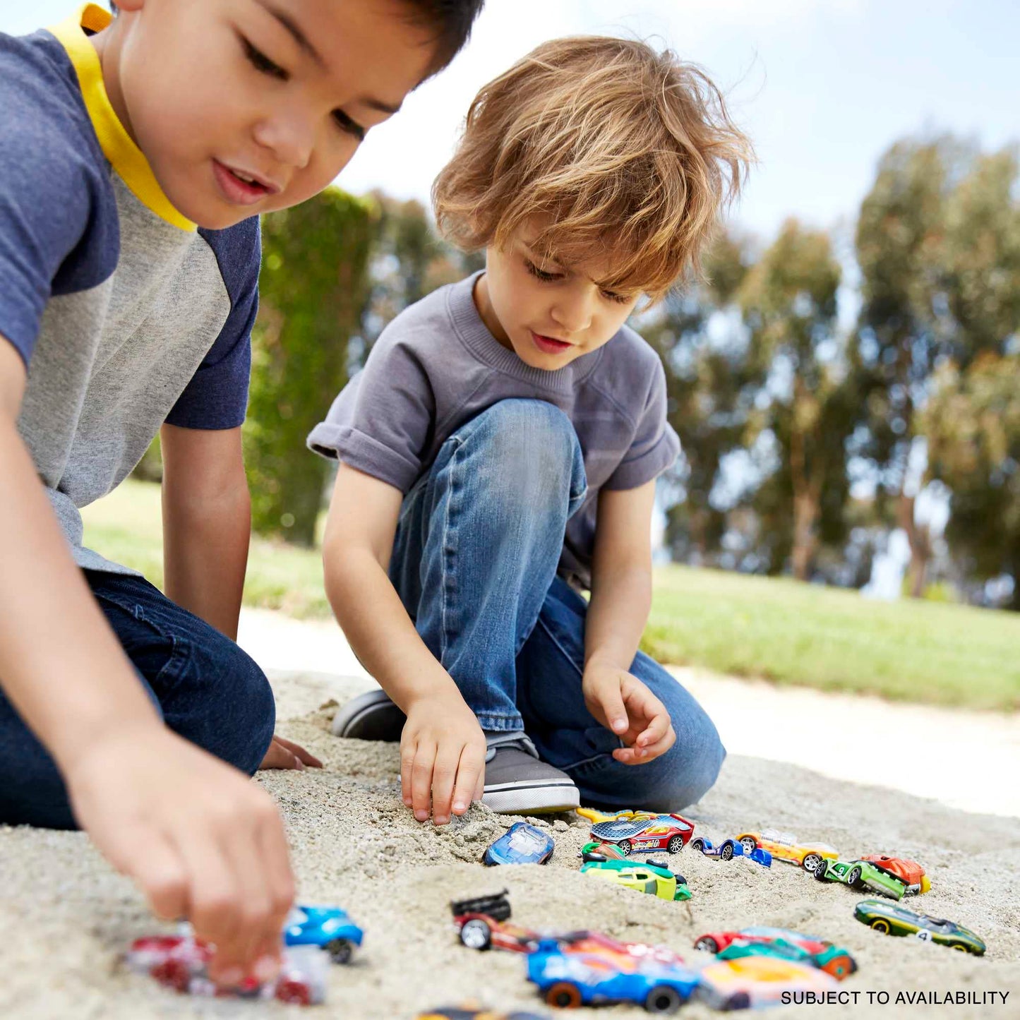 Assorted Hot Wheels toy cars and trucks in 1:64 scale, featuring die-cast styles like race cars and firetrucks.