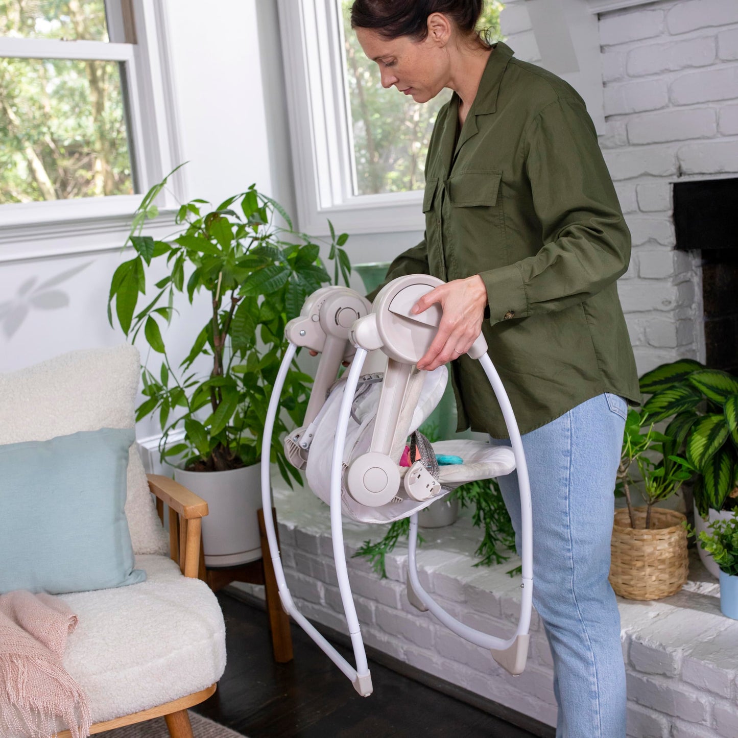 Ingenuity Soothe 'n Delight baby swing with music and toy bar, compact foldable design, suitable for travel and soothing infants.