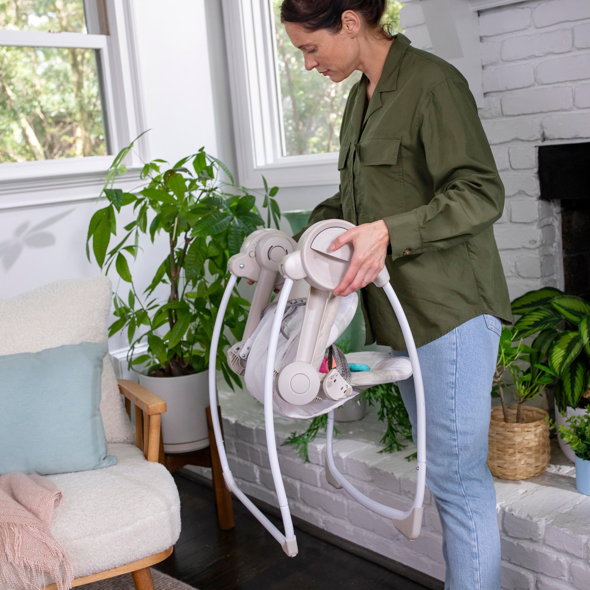 Ingenuity Soothe 'n Delight baby swing with music and toy bar, compact foldable design, suitable for travel and soothing infants.