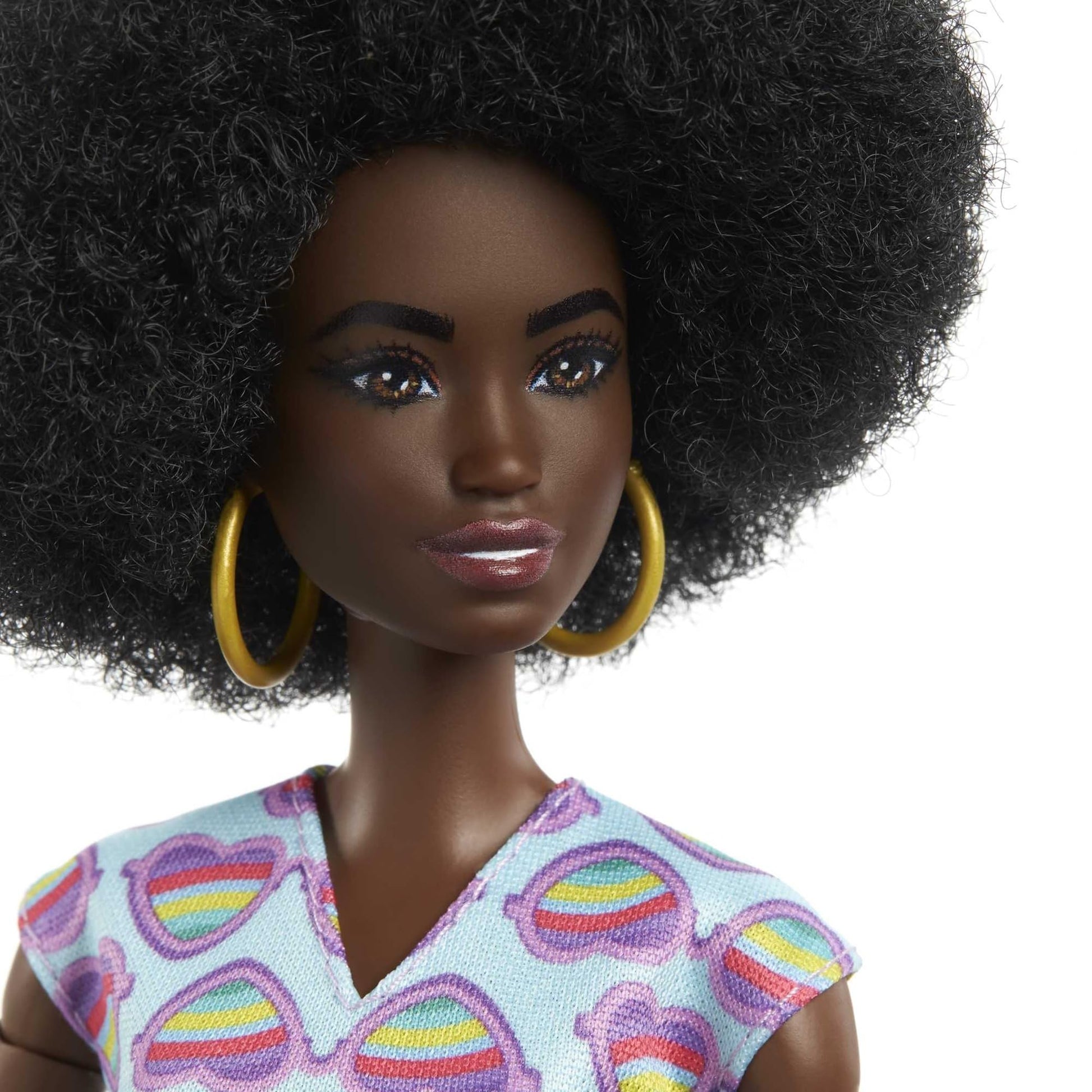 Barbie Fashionistas doll with curly black hair in a rainbow heart romper, wheelchair, and ramp for kids' play.
