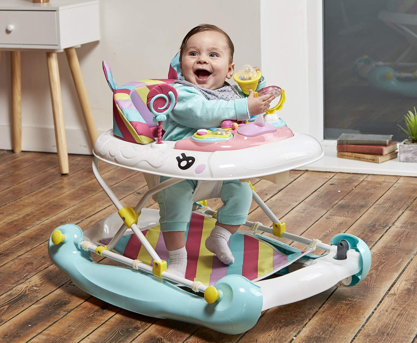 Pink MyChild Unicorn 2-in-1 baby walker and rocker with rainbow design, foldable frame, adjustable heights, and anti-fall safety blocks.