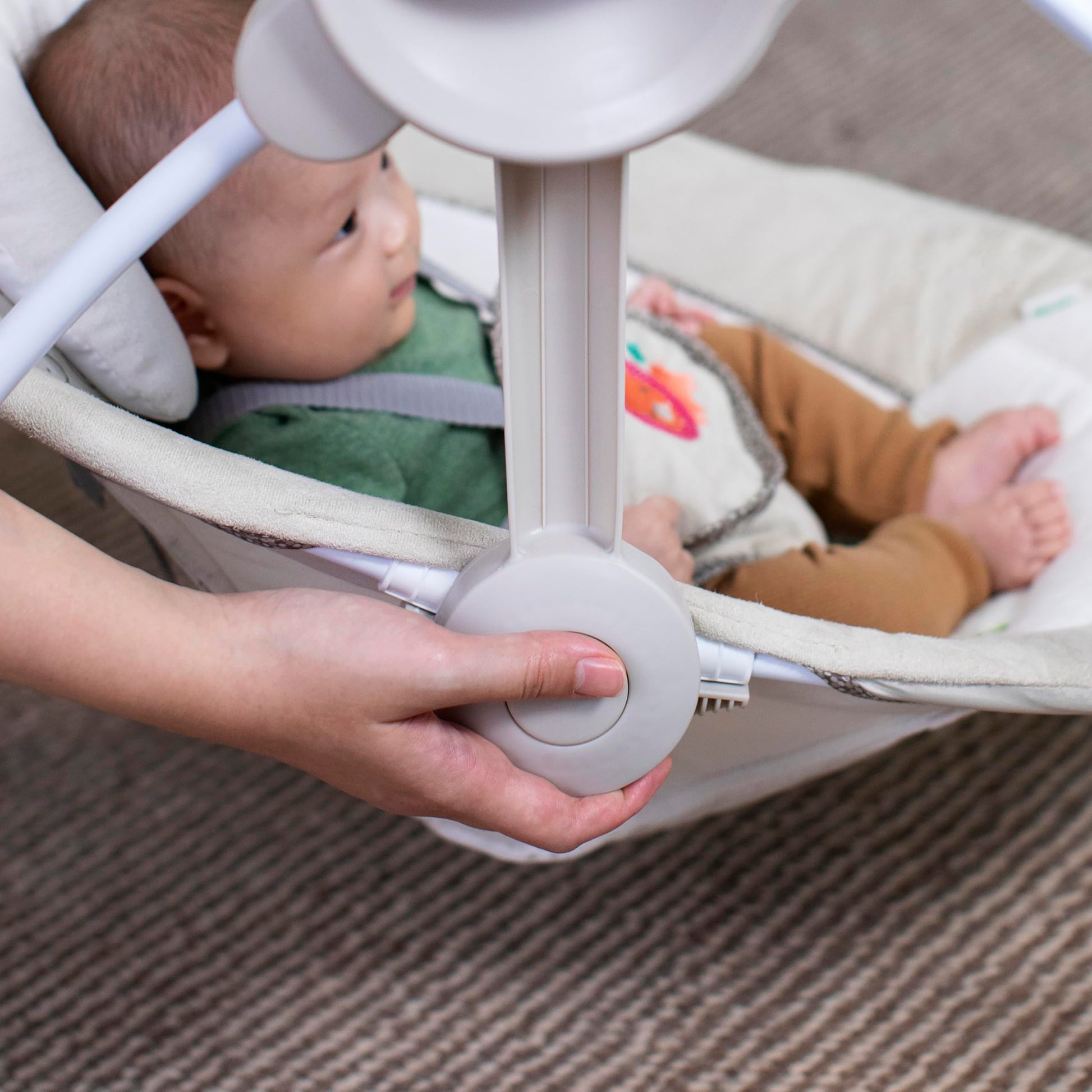 Ingenuity Soothe 'n Delight baby swing with 6 speeds, music, toy bar, compact fold for travel, in cozy fabric with baby inside.