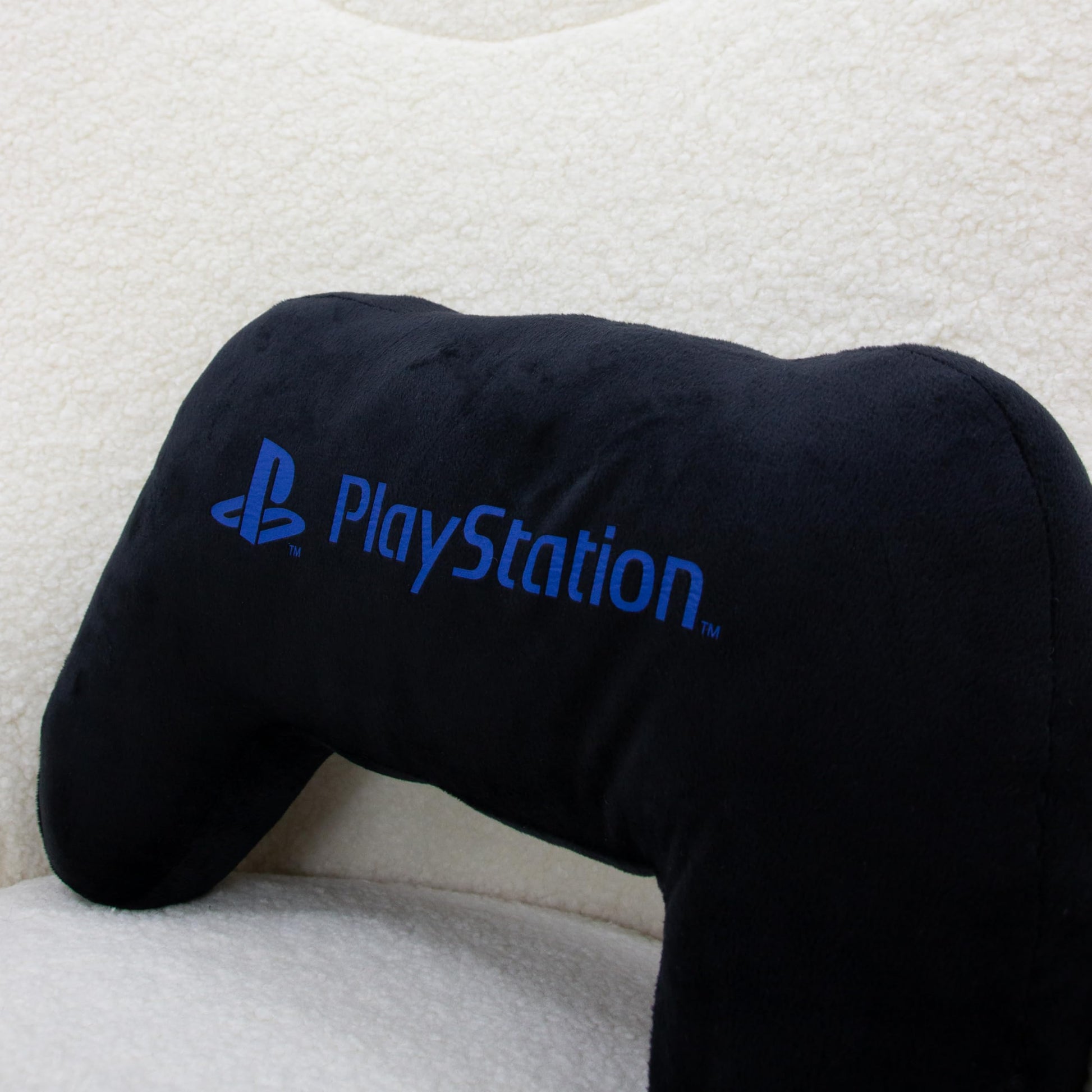 PlayStation officially licensed black controller-shaped plush pillow with glow-in-the-dark features, perfect for gaming or bedroom décor.