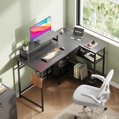 DEVAISE L-shaped gaming desk in black with monitor stand, RGB LED lights, power outlets, hook, and storage shelf for home office.