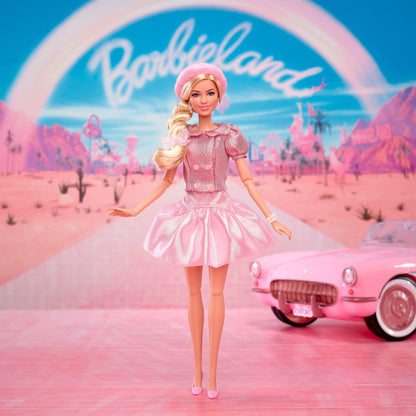 Barbie collectible doll of Margot Robbie in a pink blouse and tutu skirt, featuring styled hair and matching jewelry.
