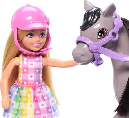 Barbie Chelsea doll riding a gray toy pony with helmet and saddle accessories, doll bending at knees for riding play.