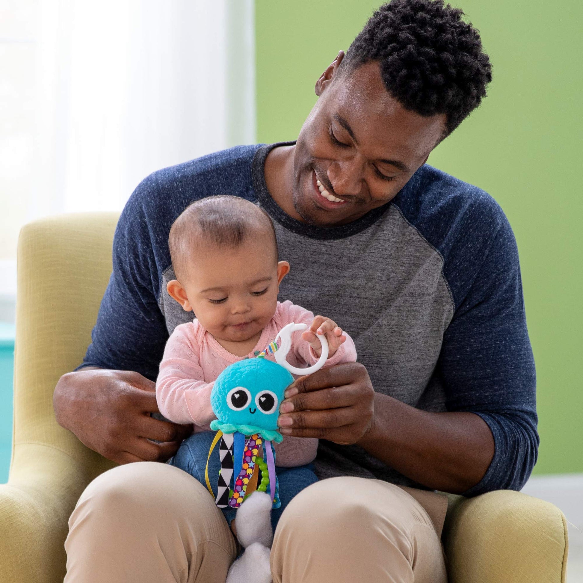Lamaze Mini Clip & Go Sprinkles Jellyfish sensory toy attached to a pram, designed for newborns 0-6 months, lightweight and colorful.