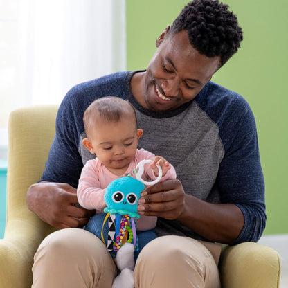 Lamaze Mini Clip & Go Sprinkles Jellyfish sensory toy attached to a pram, designed for newborns 0-6 months, lightweight and colorful.