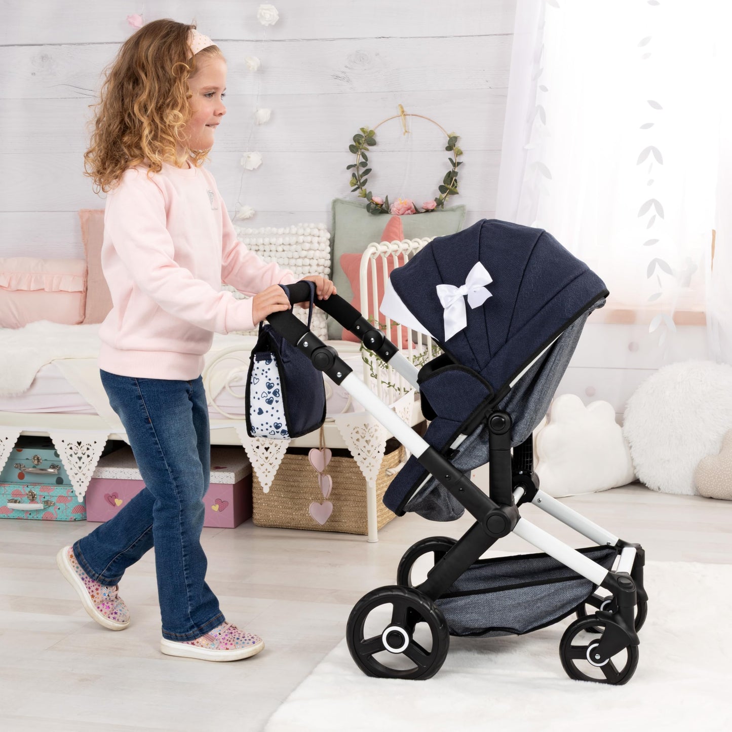 Navy blue Bayer Baby Dolls Pram XEO convertible doll stroller with adjustable handle, carrycot, changing bag, and ribbon accents.