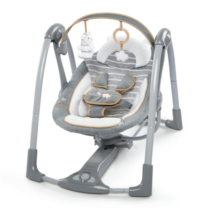 Ingenuity Swing 'n Go Deluxe baby swing with cushioned harness, plush toys, and sounds, suitable for infants 0-9 months.