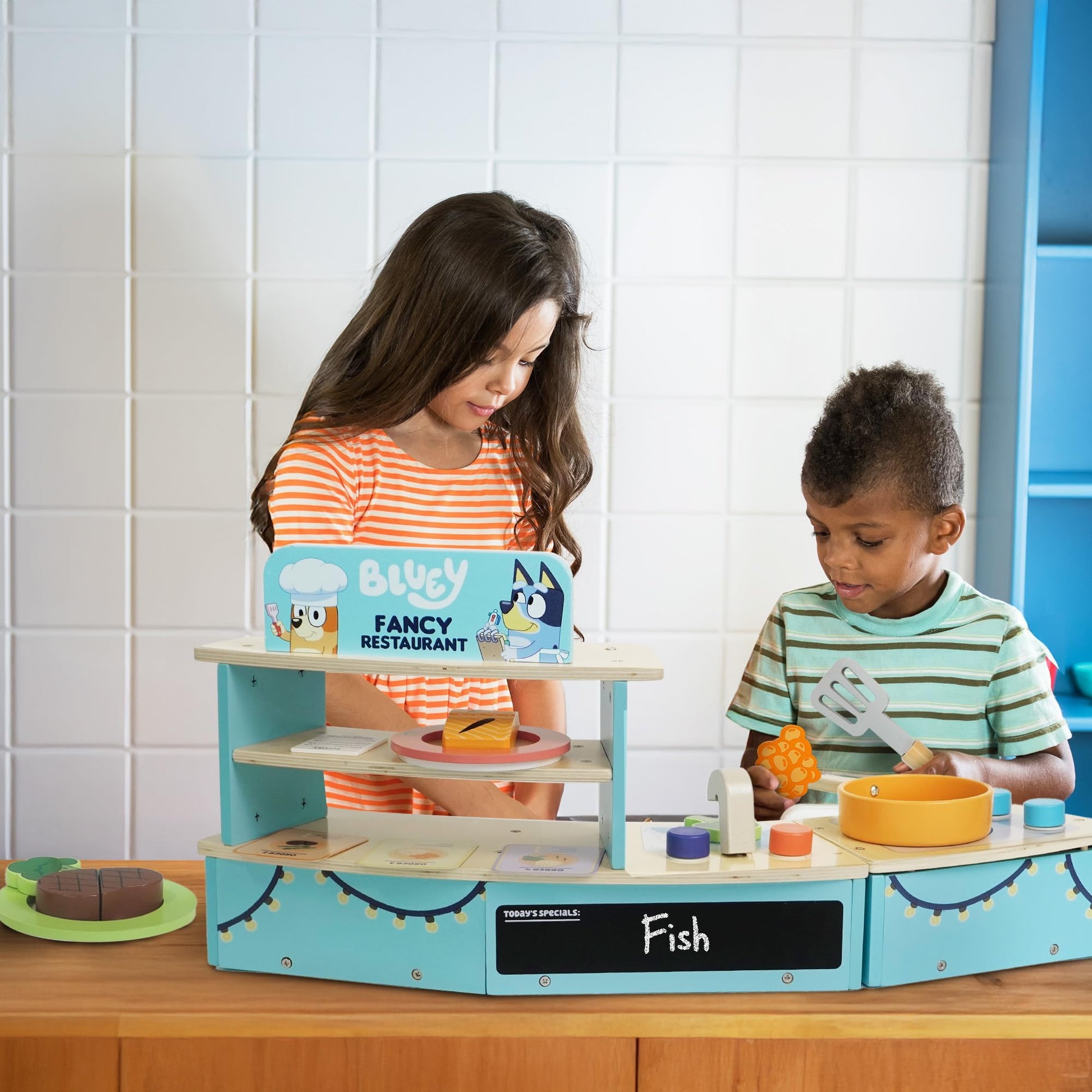 Bluey Tabletop Restaurant Playset with wooden oven, sink, fridge, and accessories for kids aged 3+ in a colorful pretend kitchen setting.