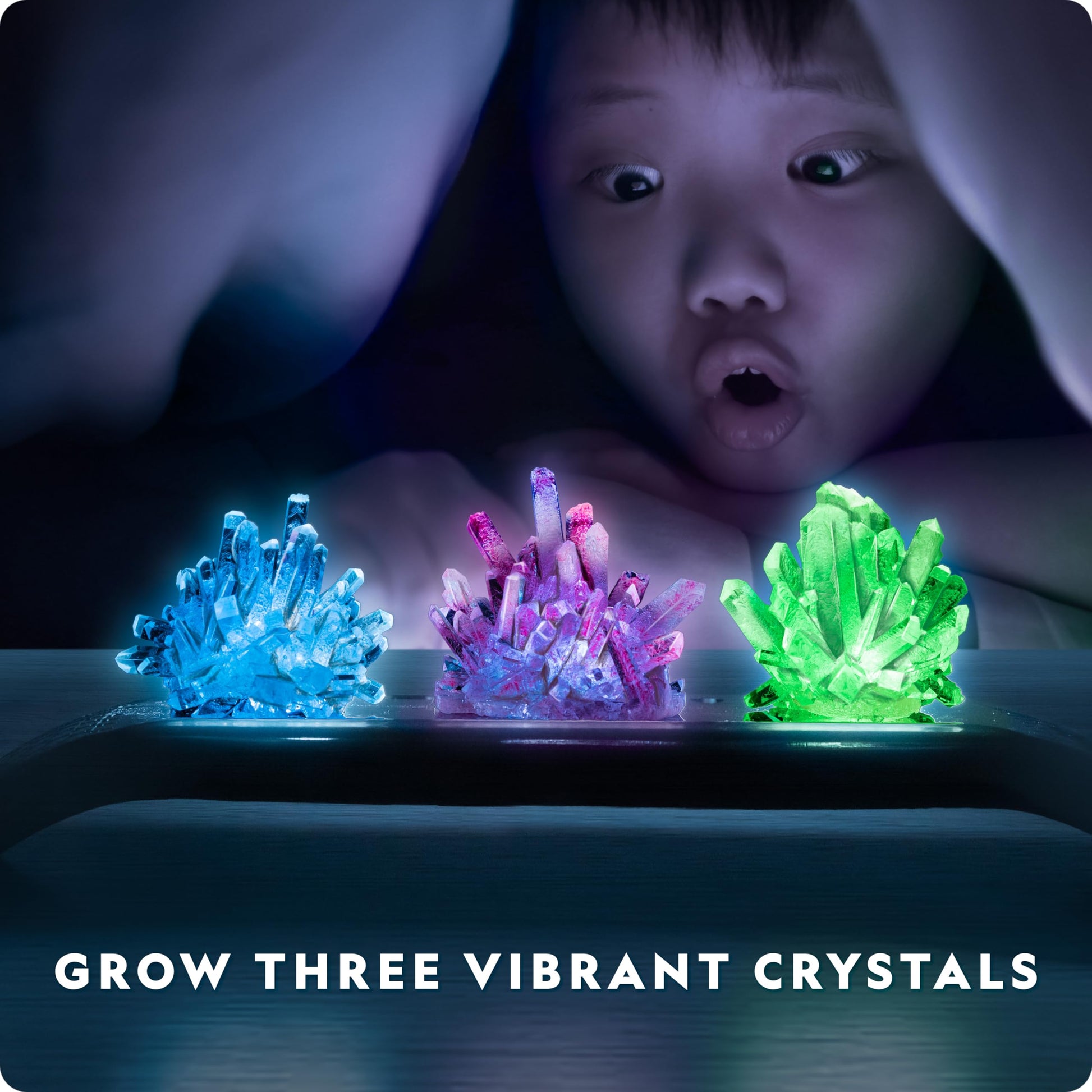 Blue Marble National Geographic Crystal Growing Kit with vibrant crystals, light-up stand, guidebook, geode, and green fluorite specimens.