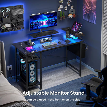 Black DOMSHOCT gaming desk with LED lights, power outlets, storage shelves, and a reversible corner design for home office use.