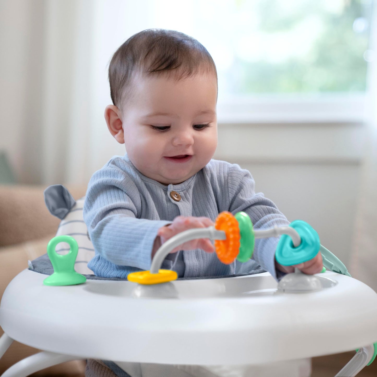 Ingenuity Smooth Strides activity walker in chambray with toys, 3-position height adjustment, suitable for 6-12 months.
