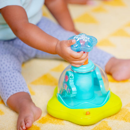 Bright Starts press and glow spinner baby toy with multicoloured lights and music, designed for infants 6 months and older.
