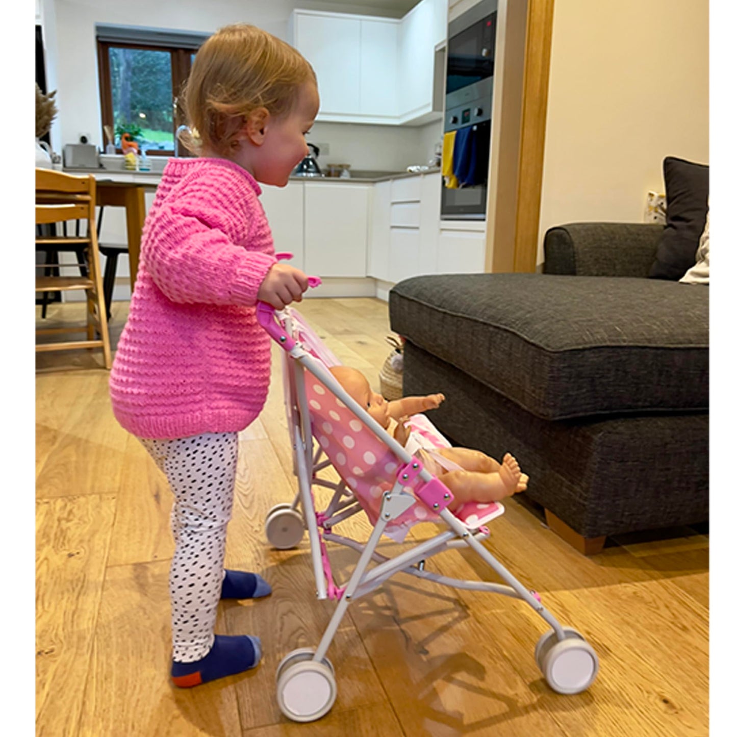 Pink Dolly Tots twin stroller with polka dot pattern, lightweight double dolls pram for kids, perfect for role play and outdoor fun.