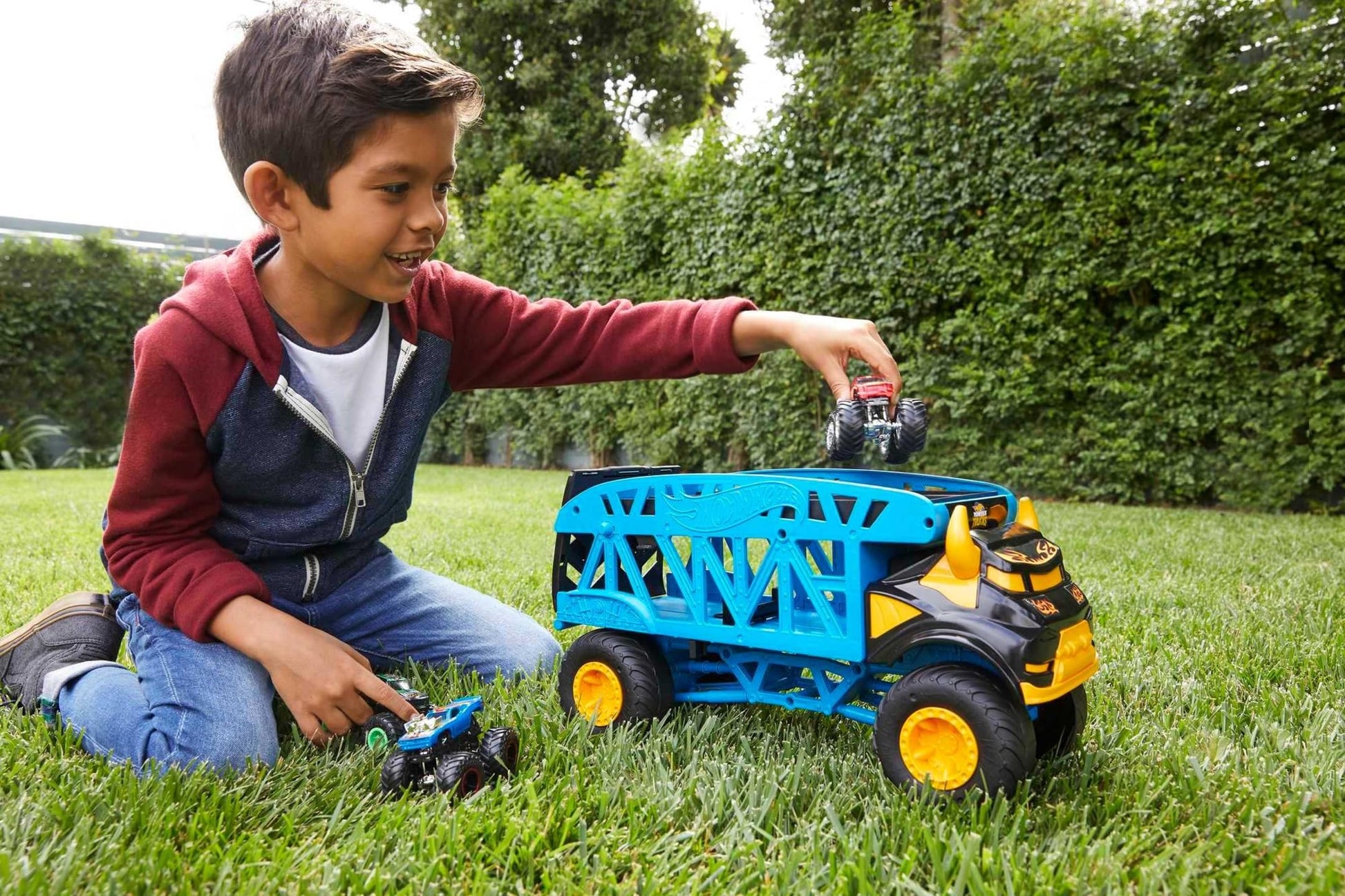 Hot Wheels GGB64 Monster Trucks set featuring three multicoloured cars in action on a vibrant play surface.