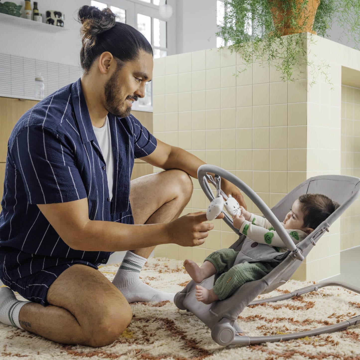 Bebeconfort Aster baby rocker with adjustable backrest, removable toy arch, 3-point harness, lightweight design, in tinted graphite.