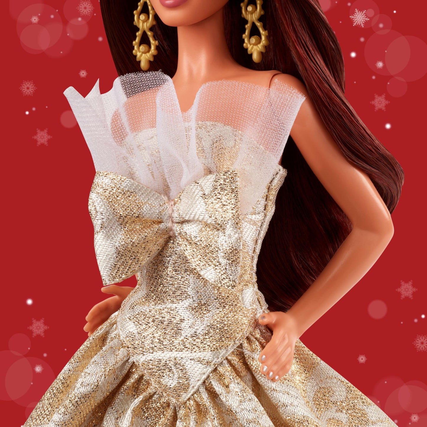 Barbie Signature 2025 Holiday fashion doll with dark brown hair in a silver and gold gown, displayed in collectible packaging.