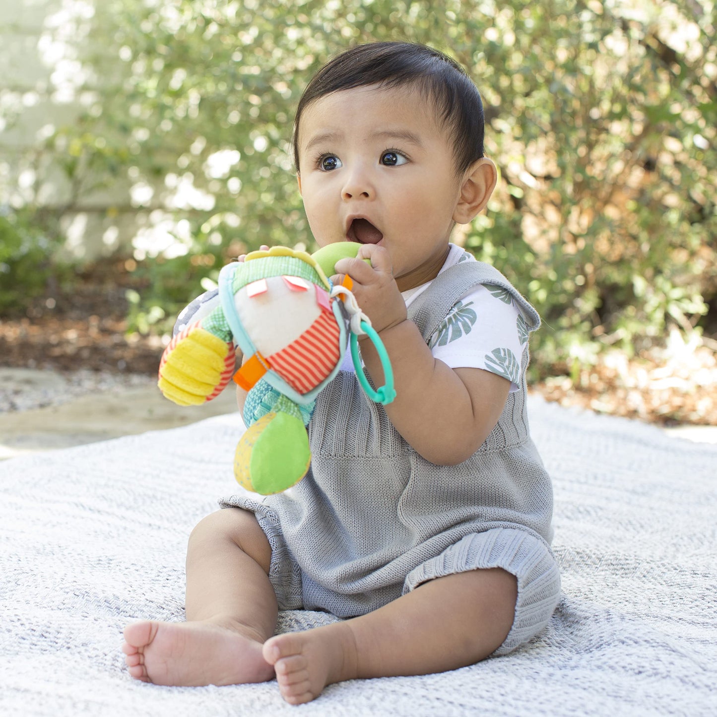 Infantino Go Gaga Turtle activity mirror clipped to a pram for tummy time, featuring colorful sensory toys for newborns and babies.