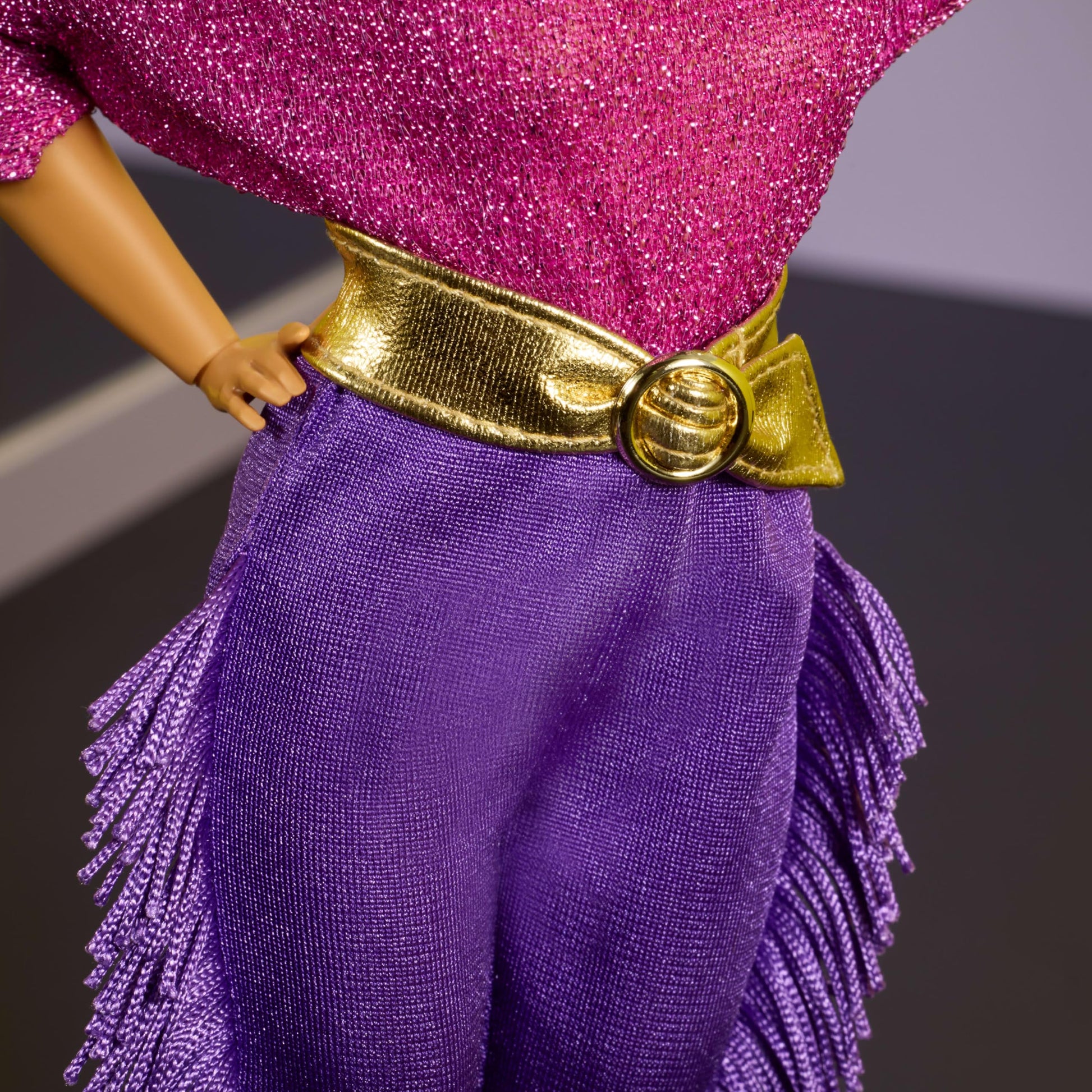 Barbie Signature Debbie Allen Tribute Doll in off-shoulder top, gold belt, purple fringe pants, and leg warmers.