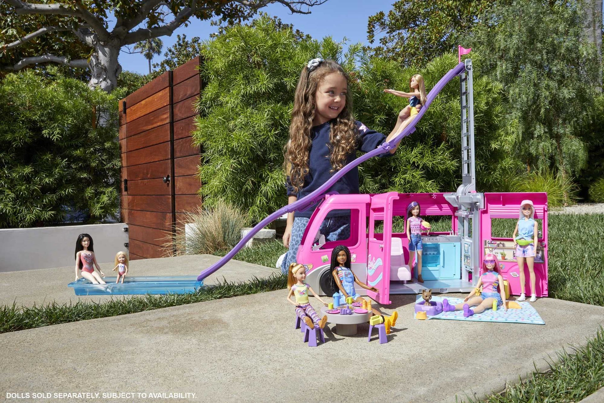 Barbie Dream Camper in pink with play areas, pool, slide, puppies, and accessories for imaginative play.