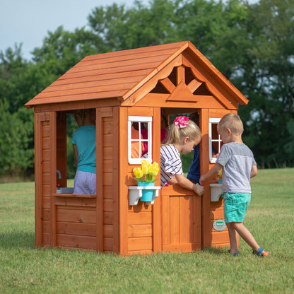 Backyard Discovery Timberlake cedar wood playhouse with toy kitchen, phone, and flowerpot holders, suitable for children aged 2-7.