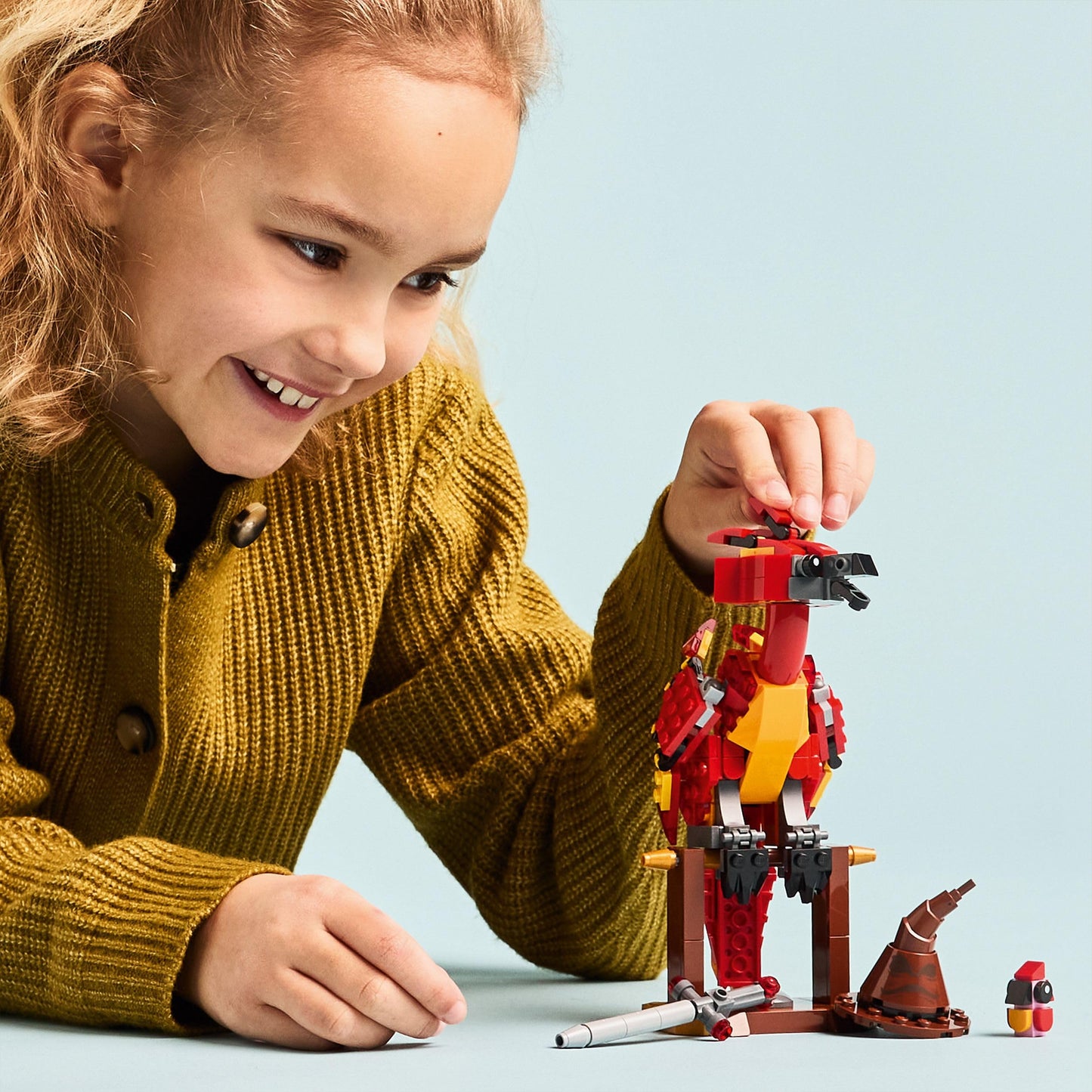 LEGO Harry Potter Fawkes figure with Sorting Hat and Sword of Gryffindor, depicting Dumbledore's Phoenix toy.